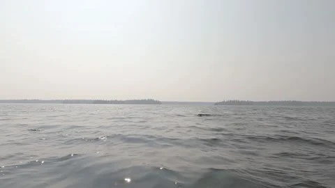 Point of view from front of canoe boat moving forward across a wavey lake on a Stock Footage 326969678