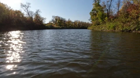 Point of view from front of canoe while paddling along a river in autumn trees Stock Footage 301109304