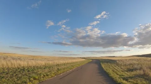 Point of view from the front of a vehicle driving along a single lane paved road Stock Footage 311737977
