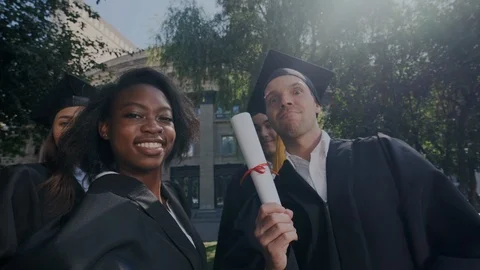 Point of view of happy mixed race graduates while they making selfie photo and Stock Footage 116185359