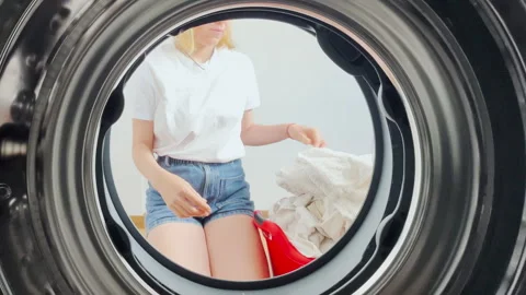 Point of view from inside a washing machine as a young woman in casual clothes Stock Footage 308397927
