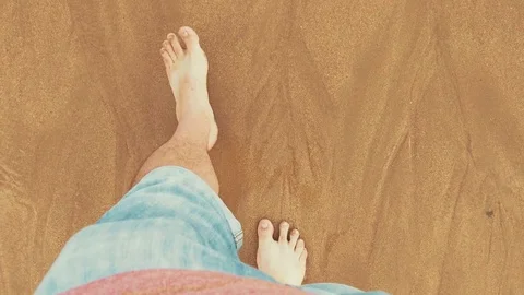 Point of view looking down at male legs with rolled up jeans and bare feet Stock Footage 71469424