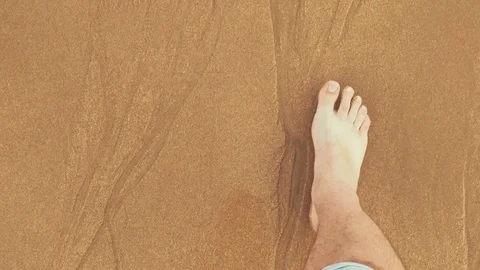 Point of view looking down at male legs with rolled up jeans and bare feet Stock Footage 71469596