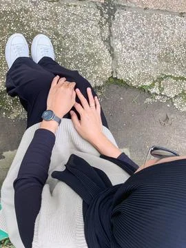 Point of view looking down at a person sitting cross legged on paved ground.. Stock Photos