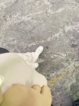 Point of view looking down at a person's casual white shoes stepping on a t.. Stock Photos