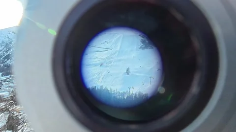 Point of view looking through telescope at ski resort 스톡 동영상 329014403
