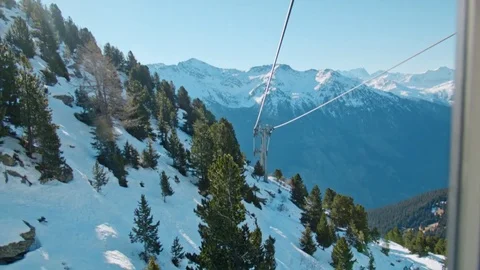 Point of view looking through window to mountains with snow &amp; threes in skilift Stock Footage 71125876