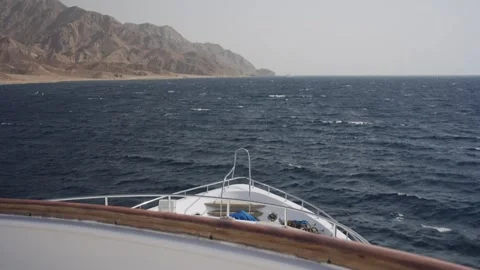 Point of view from a luxury yacht navigating through choppy blue waters along a Stock Footage 333848791