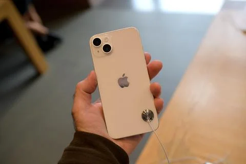 Point of view male hand holding new powerful gold colored iPhone 14 Plus new Stock Photos