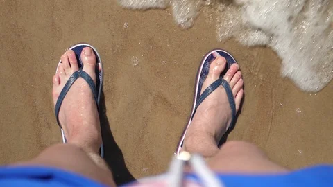 Point of view Man Beach. Legs flip flops Ocean Sandy shore Waves Slow motion Stock Footage 128524474