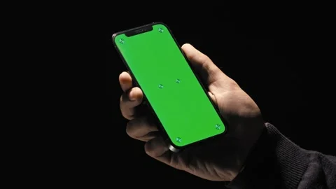 Point of view of man on black background using phone with green mock-up screen Stock Footage 167321559