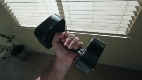 Point of View of Man Doing Dumbbell Curls by a Sunny Home Window Stock Footage 318687164