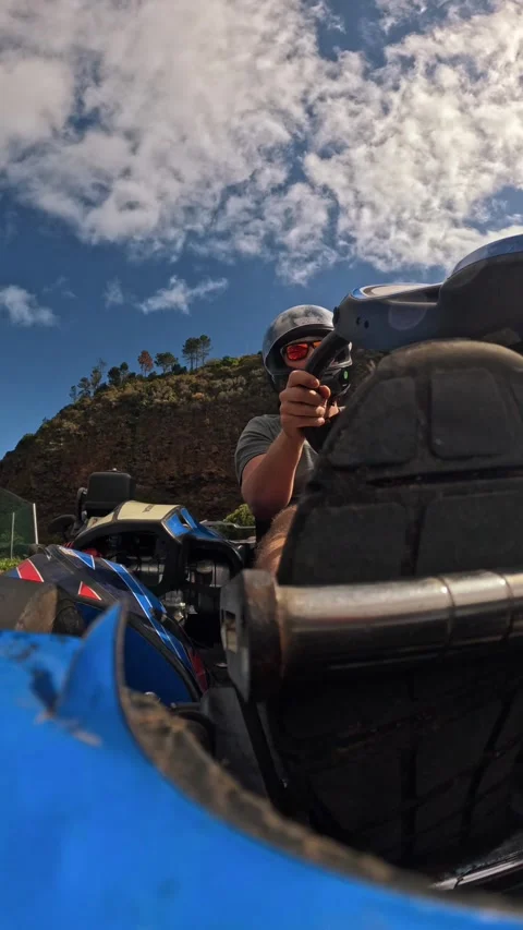 Point of view man driving his go kart on a race track with scenic mountain view Video stock 299958699