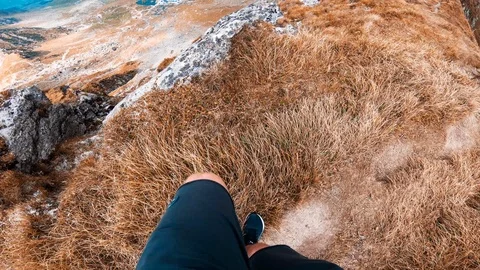Point of view man hiking on a mountain trail and reveal shot of Balea lake Stock Footage 95942383