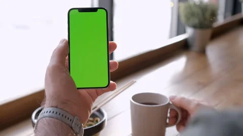 Point of View of Man person holding smartphone and scrolling on green screen Stock Footage 264608617