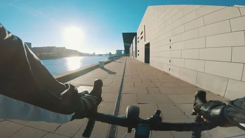 Point of view of man riding bicycle next to harbour as sun sets Stock Footage 98750633