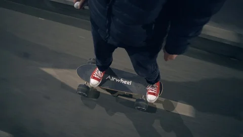 Point of view man riding an electric skateboard on a city street at night Stock Footage 87751890