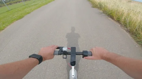 Point of view of man riding electric scooter on asphalt road in the city Stock Footage 116201251