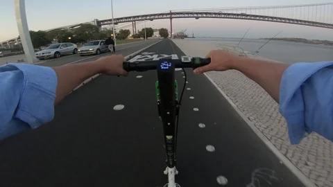 Point of view man riding an electric scooter in Lisbon 25 de Abril Bridge view Stock Footage 117349280