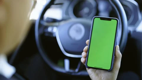 Point of View of Man Sitting at Modern Luxury Car Using Phone With Green Mock-up 스톡 동영상 194751917