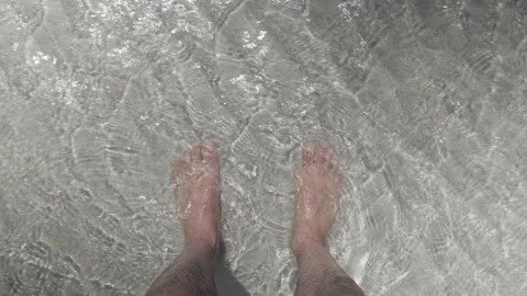 Point of view of man's feet on beach with crystalline waters Video stock 233278791