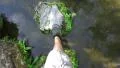 Point Of View Mans Feet Walk Across Pond On Stepping Stones 4k or 4k+ Resolution