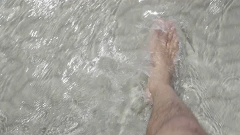 Point of view of man's feet walking in crystal clear water Stock Footage 233278931
