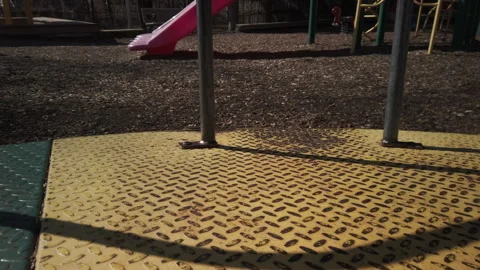 Point of view of a merry go round in motion in a children's playground, medium Stock Footage 317757910