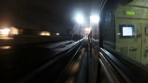 Point of view night train rushes by rail arrives and departs from platform Stock Footage 85285577