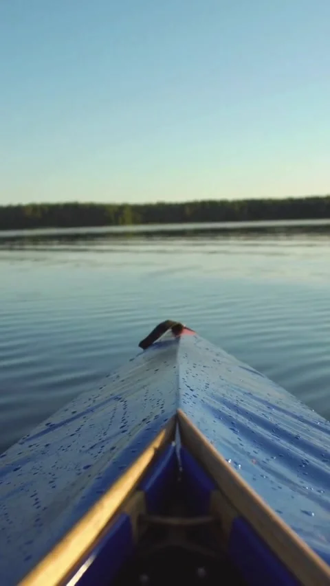 Point of view paddling a blue kayak on lake Video stock 334169557
