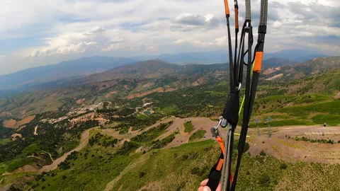 Point of view paraglider flying over the Amirsoy ski slope in Uzbekistan Stock Footage 242760869