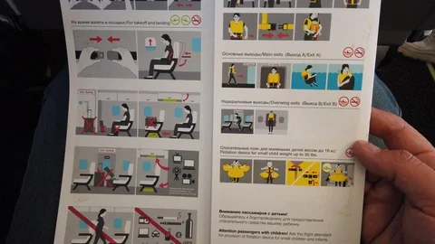 The point of view of a passenger reading a safety card on an airplane. Stock Footage 124476599