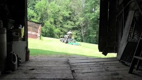 A Point of View of a Person Backing a Tractor and Mower Into a Barn Stock Footage 157159554