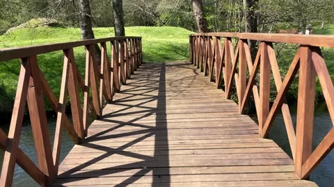 Point of view of a person trying to cross a wooden bridge on a very sunny day Stock Footage 186022654