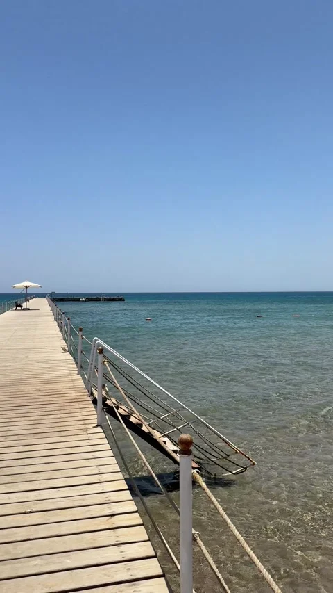 The point of view of a person walking along a wooden jetty pier that goes far Stock Footage 282802239