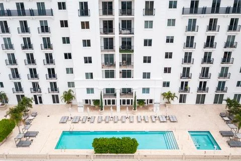 Point of view of the pool  in a hotel with several lounge chairs and umbrellas Stock Photos
