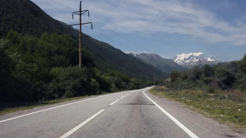 Point Of View (POV) Driving Along A Straight Asphalt Road Through A Mountain Lan Stock Footage 312962559