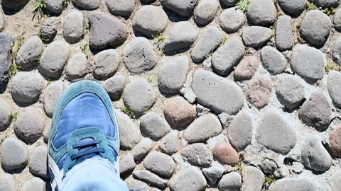 Point of view of shoes that walk on an ancient medieval paving of stones Stock Footage 106594982