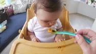 Point Of View Shot Of Baby Being Fed In High Chair Stock Footage