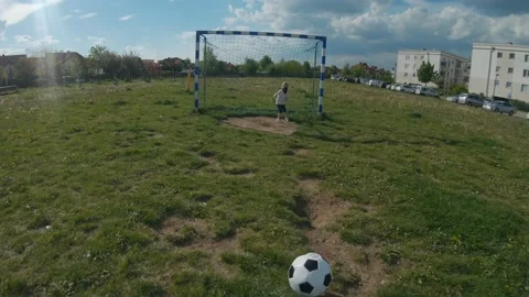 Point of view shot of boy dribbling ball when playing football with sister Stock Footage 131093550