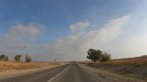 A point of view shot driving on a long straight road in desert grasslands at Stock Footage 200930108