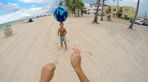 Point of View shot of kid throwing ball to another kid at the beach Stock Footage 56187286