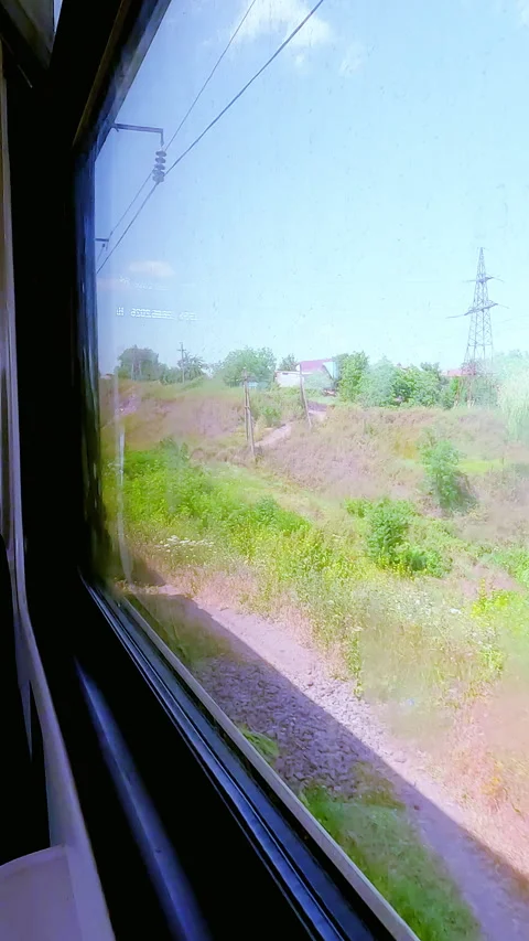 Point of view shot looking out of a passenger train window at a green summer Stock Footage 338397653