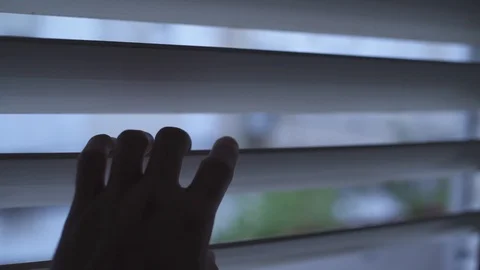 Point of view shot of a man looking outside through window shutters Video stock 109044861