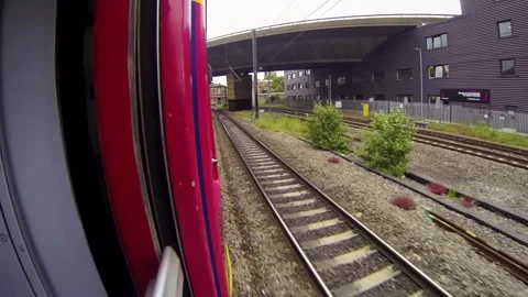 Point-of-View Shot from a red Train Window in the UK Showcasing Passing Landscap Stock Footage 297370784