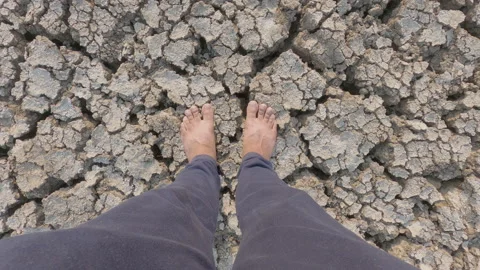 Point of view shot of a young farmer standing barefoot on a drought hit field Stock Footage 150277835