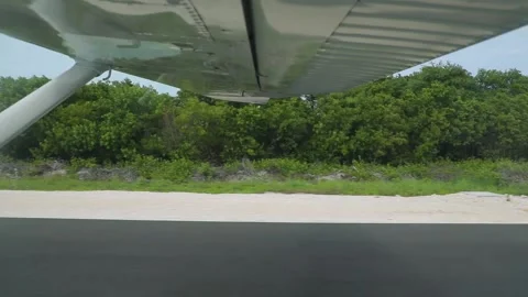 Point of view side view from airplane landing at Caribbean island green runway Stock Footage 204927443