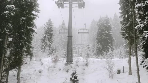 Point of view sitting on snowy ski lift chair solo ride pov passing snow co.. 库存影片 341267541