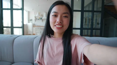 Point of view. Smiling young asian woman making selfie or video call while Vídeos de archivo 160809679