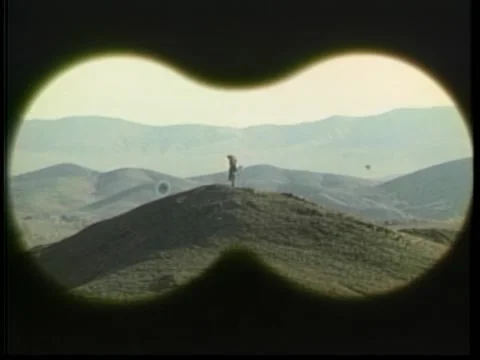 Point of view through binoculars of Arab standing on mountain Stock Footage 260258428